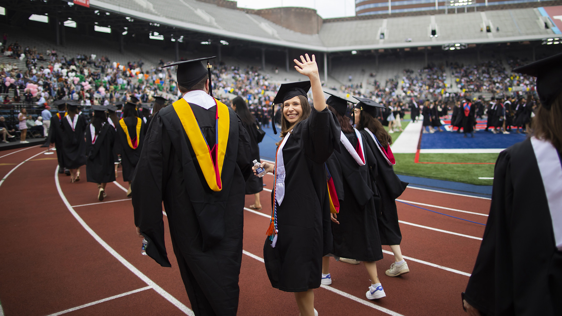 one grad turns and waves on franklin field at commencement 2022