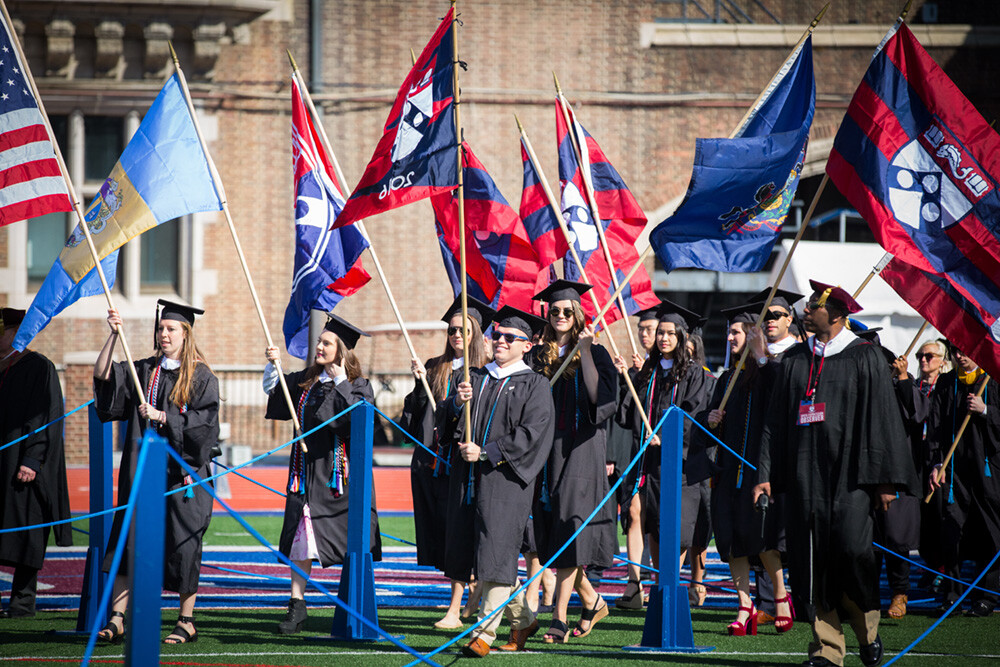 Graduates carrying flags at Penn Commencement
