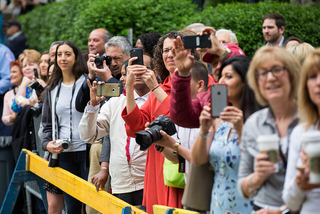 spectators of graduate procession with cameras